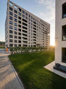 a large building with a green lawn in front of it at The Loft, An Architects Dream in Târgu-Mureş