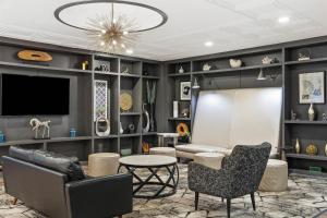 a living room with a couch and chairs and a tv at DoubleTree by Hilton Hotel Wilmington in Wilmington