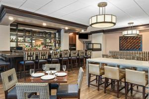 a restaurant with tables and chairs and a bar at DoubleTree by Hilton Hotel Wilmington in Wilmington