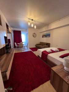 a bedroom with two beds and a red rug at Emmaia Escape Eforie Nord in Eforie Nord