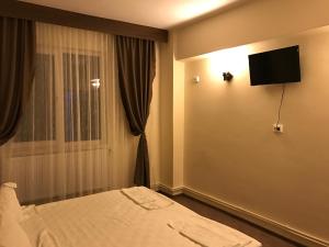 a hotel room with a bed and a flat screen tv at Romula Imperial in Caracal
