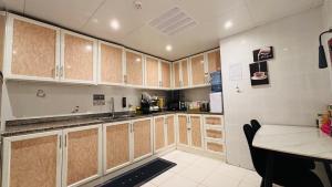 a large kitchen with wooden cabinets and a table at Haven Hub in Abu Dhabi +9 photos