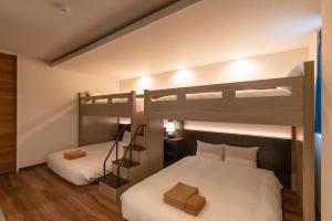 two beds in a room with two bunk beds at ReLA Minami-Nagareyama in Nagareyama