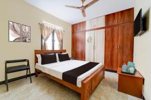 a bedroom with a bed and a television in it at Super Collection O Madurai Junction Formerly RLR Enclave in Madurai