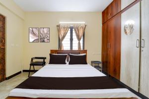 a bedroom with a large bed and a window at Super Collection O Madurai Junction Formerly RLR Enclave in Madurai