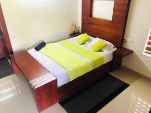 a bedroom with a bed with yellow and white sheets at Traditional Villa Munnar in Anachal