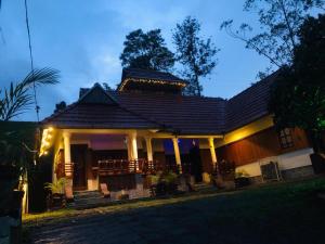 a house at night with the lights on at Traditional Villa Munnar in Anachal +20 photos