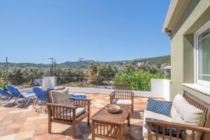 a patio with chairs and a table on a balcony at Agis Luxury House in Lefkada