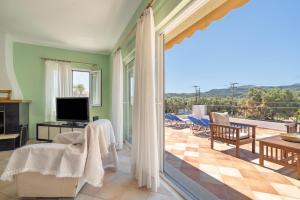 a living room with a television and a balcony at Agis Luxury House in Lefkada