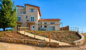 a house on a hill with a fence in front of it at EuZoea Country Home 2 Nature Escape with Pool in Kapandrítion