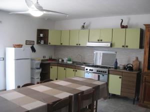 a kitchen with green cabinets and a table and a refrigerator at Appartamento open space al civico 29 in Collestrada +9 photos