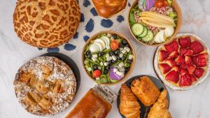a table topped with different types of food and bread at 1 Chambre Moyenne avec television in Charleroi