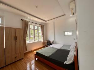 a bedroom with a bed and a large window at Hammer Homestay in Danang