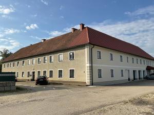a large white building with a red roof at Gästezimmer am Bauernhof in Behamberg