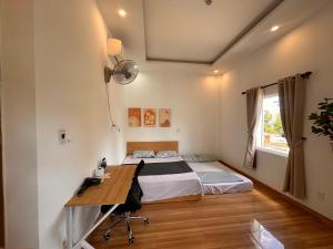 a bedroom with a bed and a desk and a window at Hammer Homestay in Danang