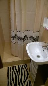 a bathroom with a sink and a shower curtain at Apartment LULU in Vysoke Tatry - Strbske Pleso