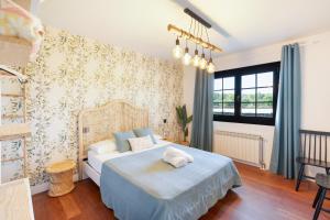 a bedroom with a bed with blue sheets and a window at Camino Blanco in Ibeas de Juarros +28 photos