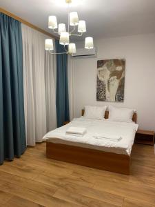 a bedroom with a bed and a chandelier at DATIVO HOUSE in Mamaia Sat/Năvodari