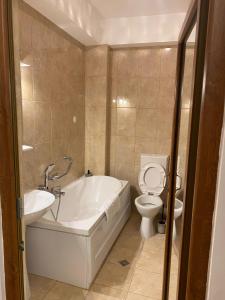 a bathroom with a tub and a toilet and a sink at DATIVO HOUSE in Mamaia Sat/Năvodari +61 photos