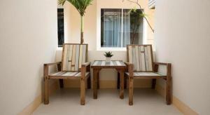 a table and two chairs sitting next to a window at Lotusland Resort in Jomtien Beach