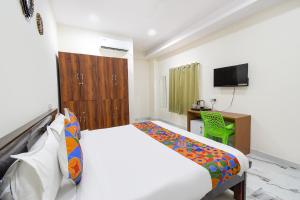 a bedroom with a bed and a desk and a television at FabHotel Latitude in Hyderabad