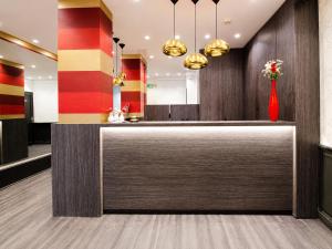 a lobby with a reception counter with a vase of flowers at Hotel Migny Opéra Montmartre in Paris +101 photos