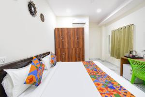 a bedroom with a bed and a desk and a bed at FabHotel Latitude in Hyderabad