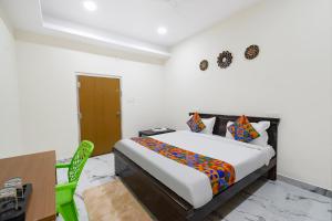 a bedroom with a bed and a table and a desk at FabHotel Latitude in Hyderabad