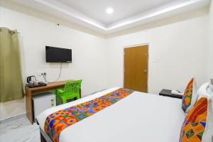 a bedroom with a bed and a desk and a television at FabHotel Latitude in Hyderabad +32 photos