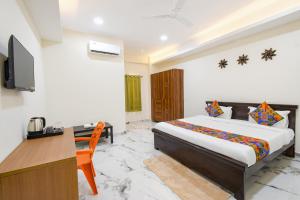 a bedroom with a bed and a desk and a television at FabHotel Latitude in Hyderabad