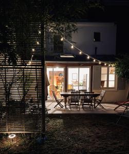 a patio with a table and chairs and lights at Maison Jardin - Centre Angers in Angers