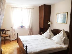 a bedroom with a bed with white sheets and a window at Hotel Krone in Laudenbach