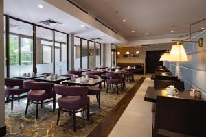 a restaurant with tables and chairs and windows at Hilton Strasbourg in Strasbourg