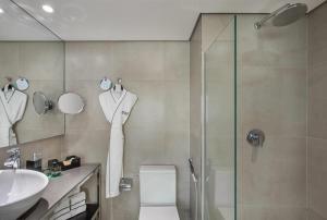 a bathroom with a shower and a toilet and a sink at Meliá Ibirapuera in São Paulo