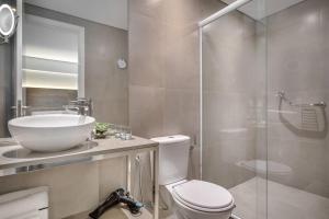 a bathroom with a toilet and a sink and a shower at Meliá Ibirapuera in São Paulo