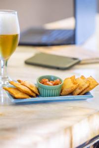 a plate of food with a glass of beer and dip at Meliá Ibirapuera in São Paulo +94 photos