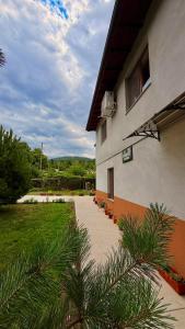 a building with a walkway next to a yard at Jenny House in Sapareva Banya
