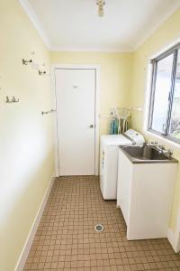 a small kitchen with a sink and a white door at Manilla Cottage - Manilla NSW in Manilla +15 photos