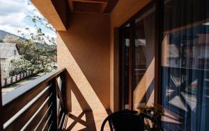 a balcony with a chair and a window with a view at Anamyra in Mizhhirya