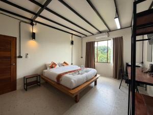 a bedroom with a bed and a desk in it at Mountainblues Hotel in Pai