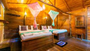 a room with two beds in a wooden cabin at Golden Rainbow Guest House in Dambulla
