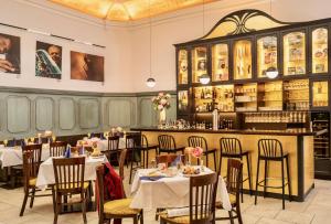 a restaurant with tables and chairs and a bar at Hotel Münchner Hof und Blauer Turm in Regensburg