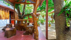a wooden table and benches in front of a tree at Golden Rainbow Guest House in Dambulla
