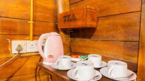 a table with cups and a coffee maker on it at Golden Rainbow Guest House in Dambulla