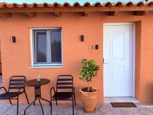 a table and chairs in front of a building with a door at LemonTreesHouses 1 Peaceful Stay Near Athens Airport & Rafina Port in Pikérmion