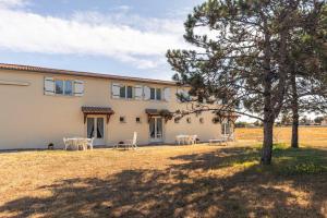 an external view of a house with tables and a tree at Duplex N°1 - Résidence Balnéaire in Le Port-des-Barques
