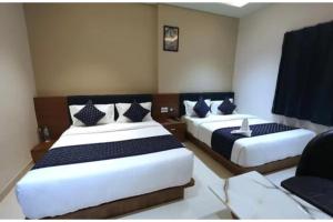 a bedroom with two beds with blue and white pillows at FabHotel The Crystal in Udaipur