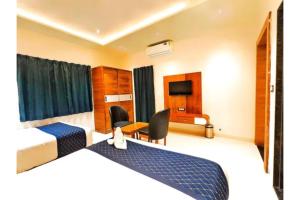 a hotel room with two beds and a television at FabHotel The Crystal in Udaipur