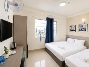 a hotel room with two beds and a television at Sleep & Go Capsule Hostel Bui Vien District 1 in Ho Chi Minh City