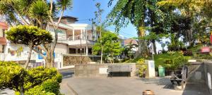 a park with a bench in front of a house at Hotel Indria in Bukittinggi